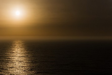 sun setting the mist of the atlantic ocean