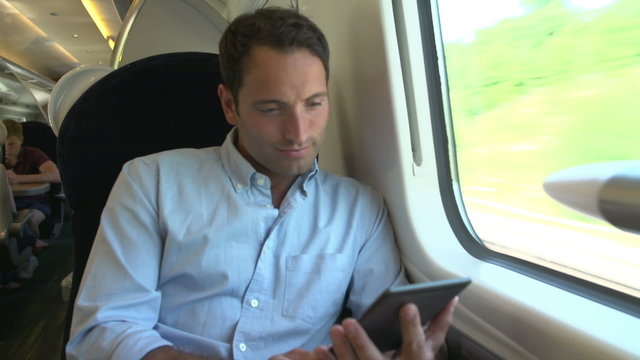Man Reading E Book On Train Journey
