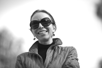Portrait of a beatiful stylish woman in sunglasses smiling wide