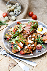 Many delicious bruschetta with cheese, tomato, quail egg, ham