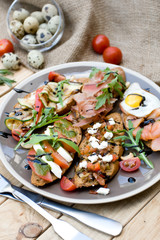 Many delicious bruschetta with cheese, tomato, quail egg, ham