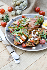 Many delicious bruschetta with cheese, tomato, quail egg, ham