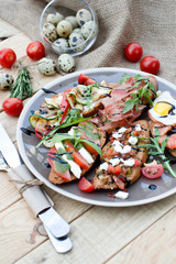 Many delicious bruschetta with cheese, tomato, quail egg, ham