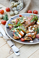 Many delicious bruschetta with cheese, tomato, quail egg, ham