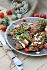 Many delicious bruschetta with cheese, tomato, quail egg, ham