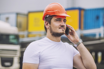 Builder man working with a cell phone in a protective helmet