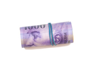 Swiss thousand francs in a roll on white background