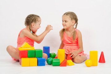 Girl frighten another girl playing with blocks