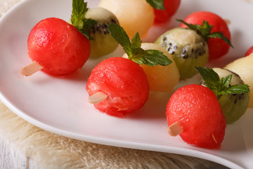 Balls of watermelon, kiwi and melon on skewers closeup. horizontal
