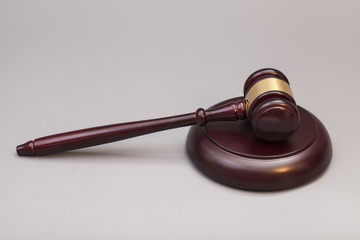 wooden judge gavel and soundboard on grey background