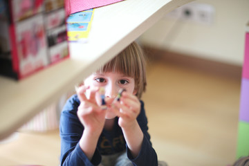 Face of a boy playing under the table in the playroom