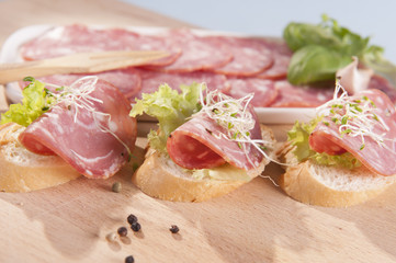 sandwiches made from dry sausage on a wooden board 