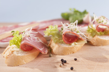 sandwiches made from dry sausage on a wooden board 