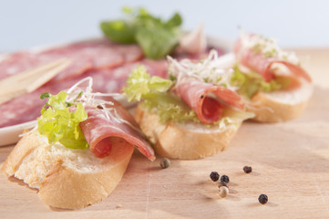 sandwiches made from dry sausage on a wooden board 