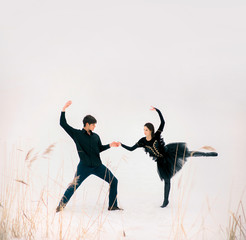 Couple of young ballet dancers perform outdoor in winter on snow