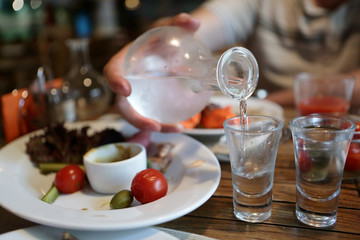 Obraz na płótnie Canvas Person pouring vodka from the decanter