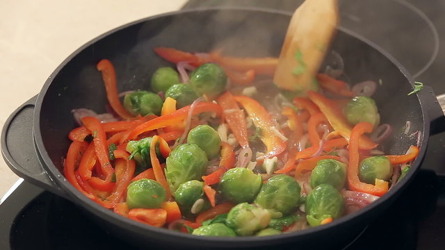 Red Paprika, Brussel Sprouts and Onions Frying on a Pan