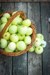 White apple variety Papirovka in a wicker basket on an old woode