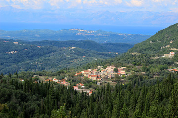 Fototapeta na wymiar View of the village in a mountain valley. Mountain view and sea view. Ionian sea and Paleokastritsa