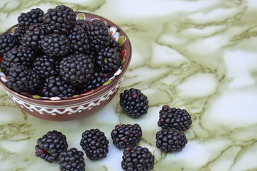 Blackberries in a dish and sprinkled around