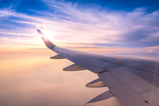 Looking through window aircraft wing during flight and look cloud in beautiful