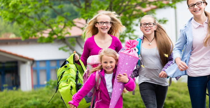 Gruppe Sch&uuml;ler auf dem Schulhof l&auml;uft in die Schule
