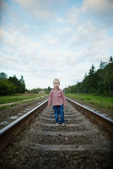 boy playing on the railroad