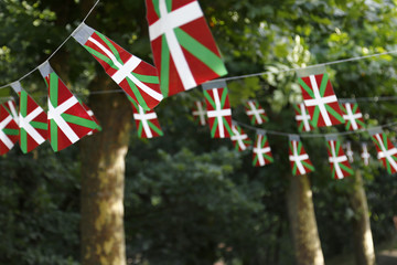 Basque country flags flying in a park with trees - obrazy, fototapety, plakaty