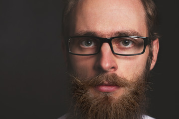 Close up stylish gorgeous young  businessman with long beard on black background