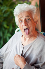 Portrait of senior woman poking out tongue