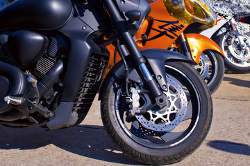 Image of different motorcycles standing beside