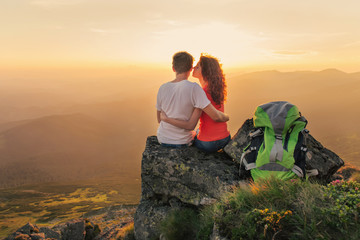 Happy couple enjoy beautiful view in the mountains - obrazy, fototapety, plakaty