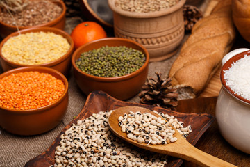 The white rice, black eyed peas, lens, beans and buckwheat in ceramic bowls on the table
