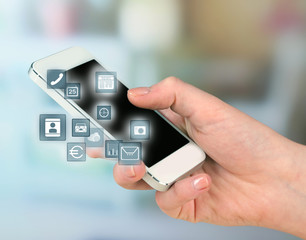 Smart-phone in hand and buttons around on blurred color background
