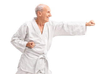 Old man in a white kimono practicing karate