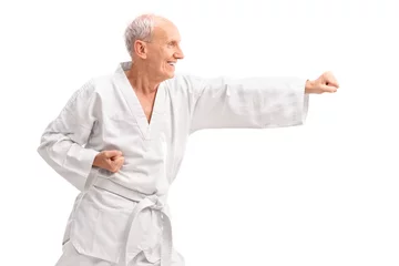 Afwasbaar Fotobehang Vechtsport Old man in a white kimono practicing karate