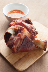 German BBQ pork knuckle served with sauce on wood background