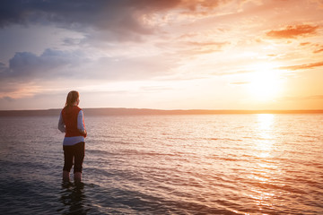 young woman watching sea sunrise
