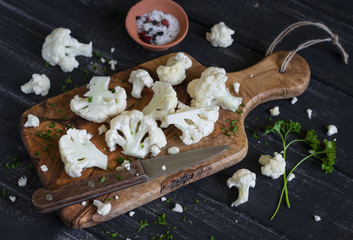 raw chopped cauliflower on a dark wooden surface