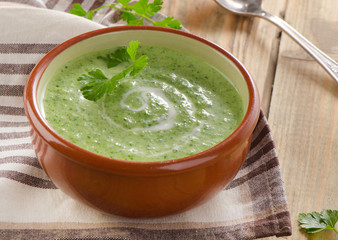 Creamy vegetable soup on  wooden table.