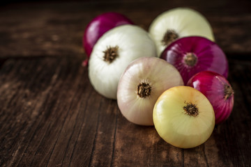 Different raw onion on wooden background