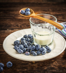 Gardening blueberries with a glass of fresh milk and honeycombs