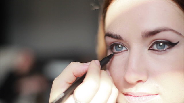 Professional make-up artist applying winged eyeliner. Close-up