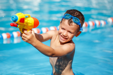 Little boy shooting with water gun