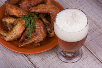 Beer and chicken wings on wooden background