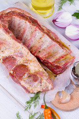 Marinated Fresh Raw Pork Ribs, Olive Oil, Chili Pepper, Red Onion And Greens on Wooden Background