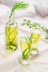 Bright summer drink tarragon in glass bottles and glasses