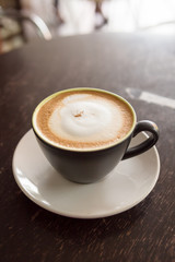 hot cappuccino on wood table and morning light in background