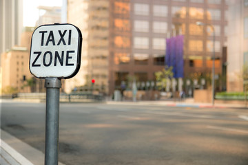 Taxi zone sign bokeh blurred blurry background urban city business district buildings downtown