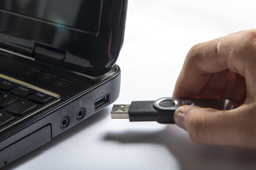 Hand inserting usb memory stick to laptop computer
